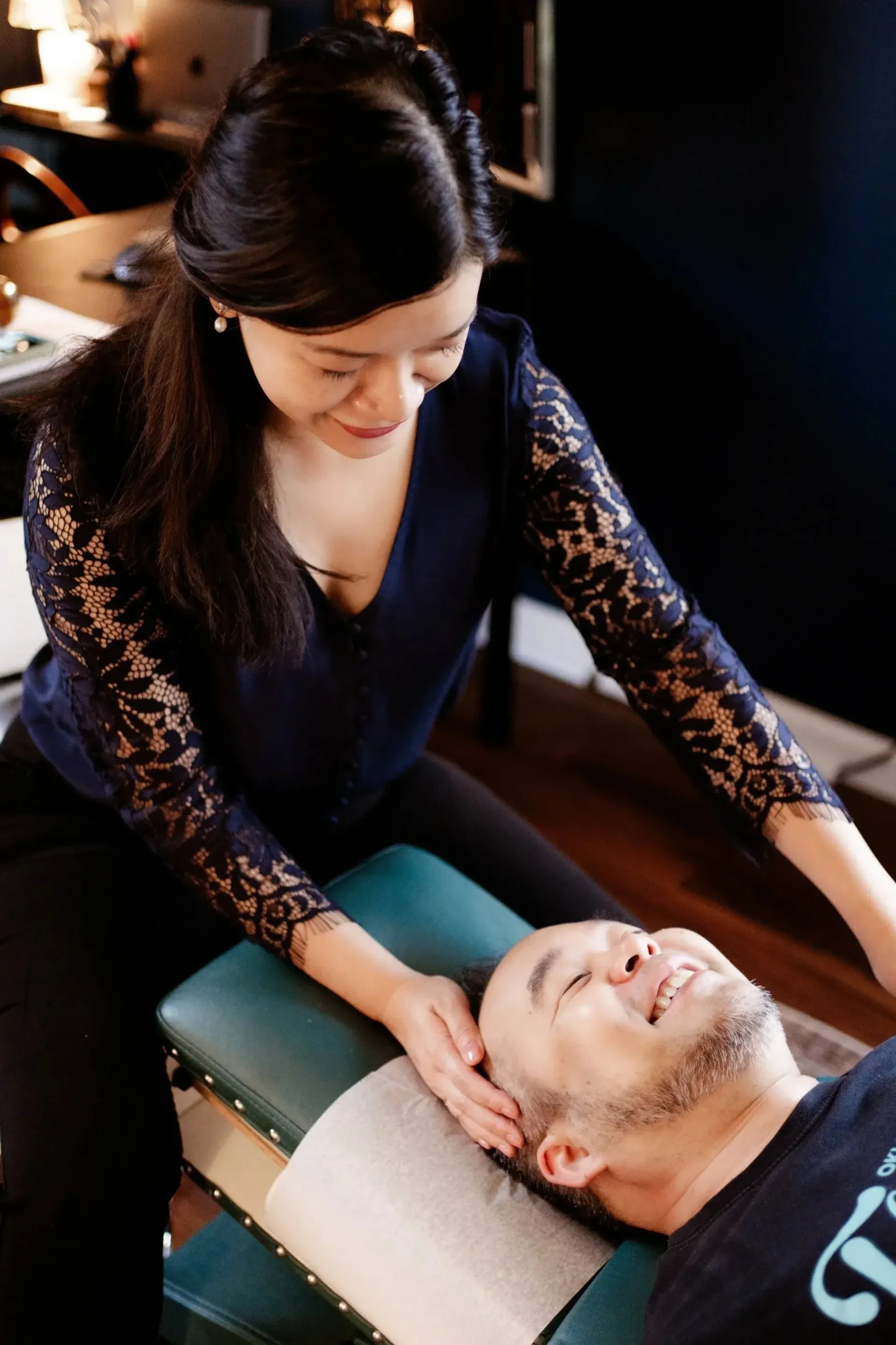Two people seated in a room during a hand massage or physical therapy session