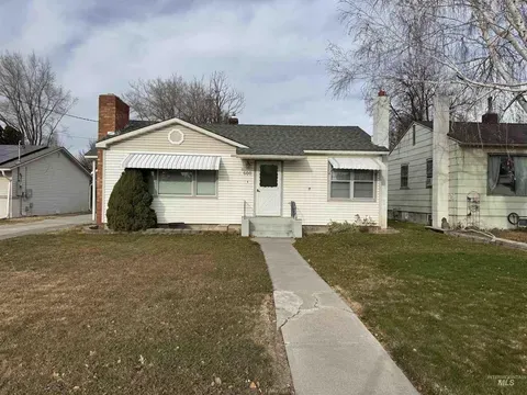 Single-story white house with a front walkway and small lawn on an overcast day