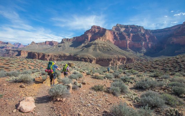 Hikers with backpacks on a trail in Grand Canyon.