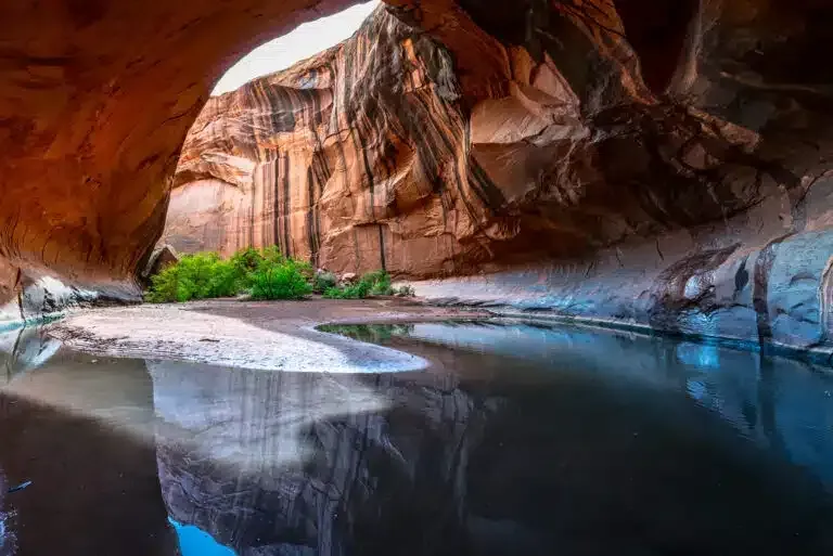 A cave with a pool of water in the middle of it.