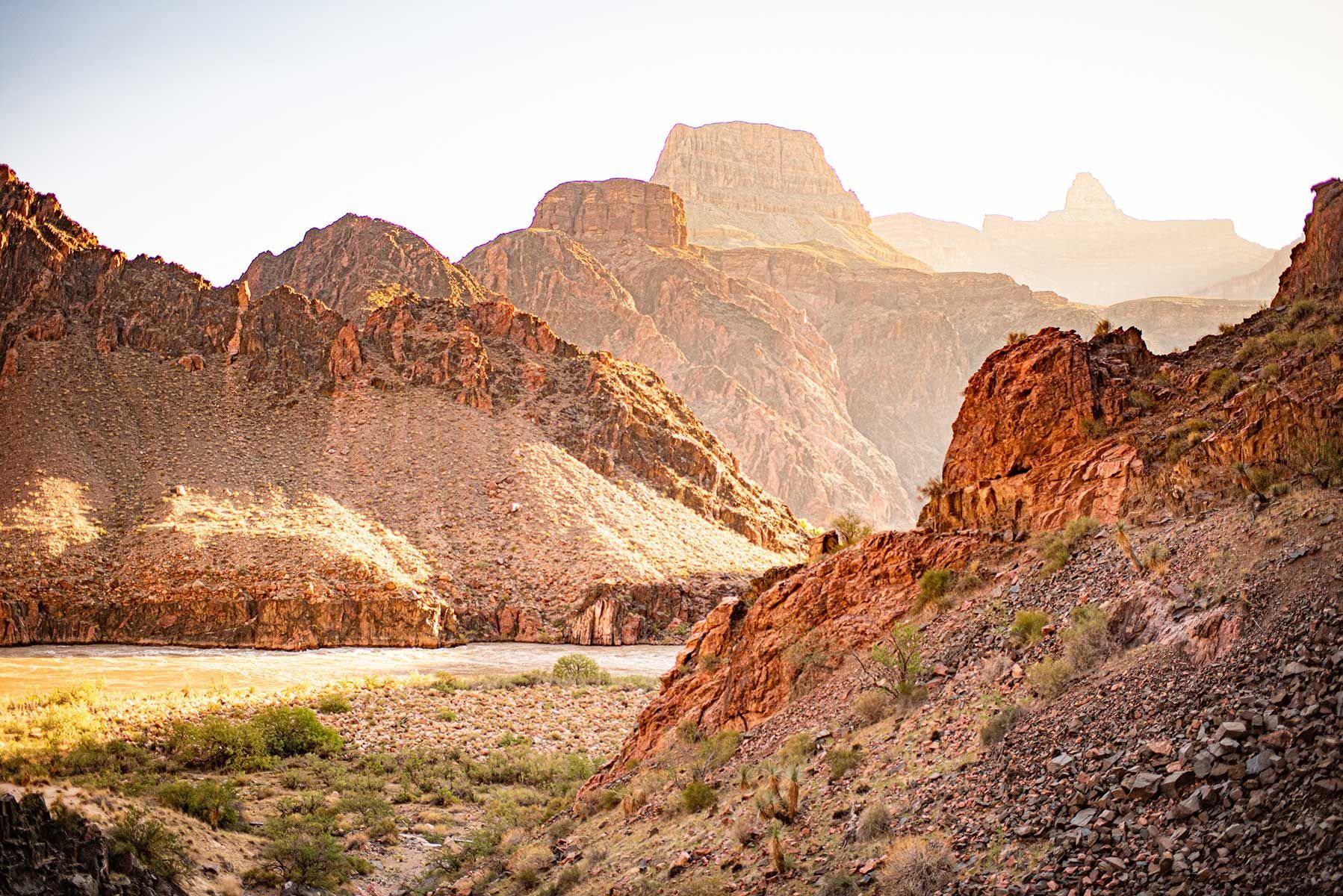 There is a river in the middle of the desert surrounded by mountains.