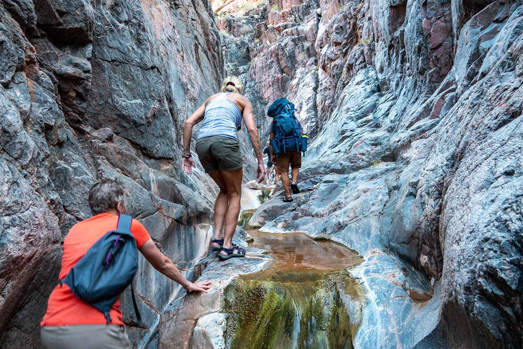 People hike up through a narrow canyon