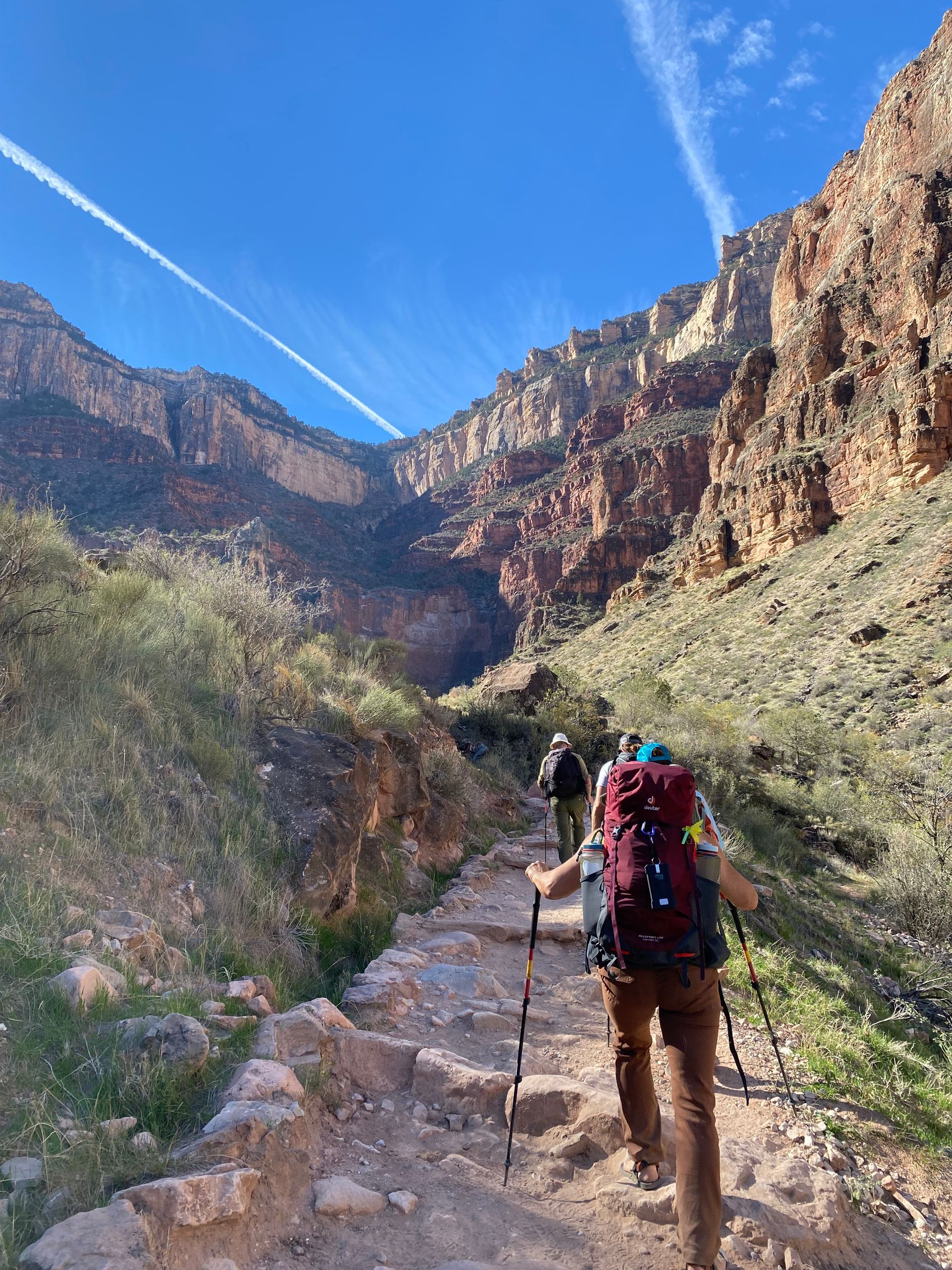 A group of people are hiking down a trail in the mountains.