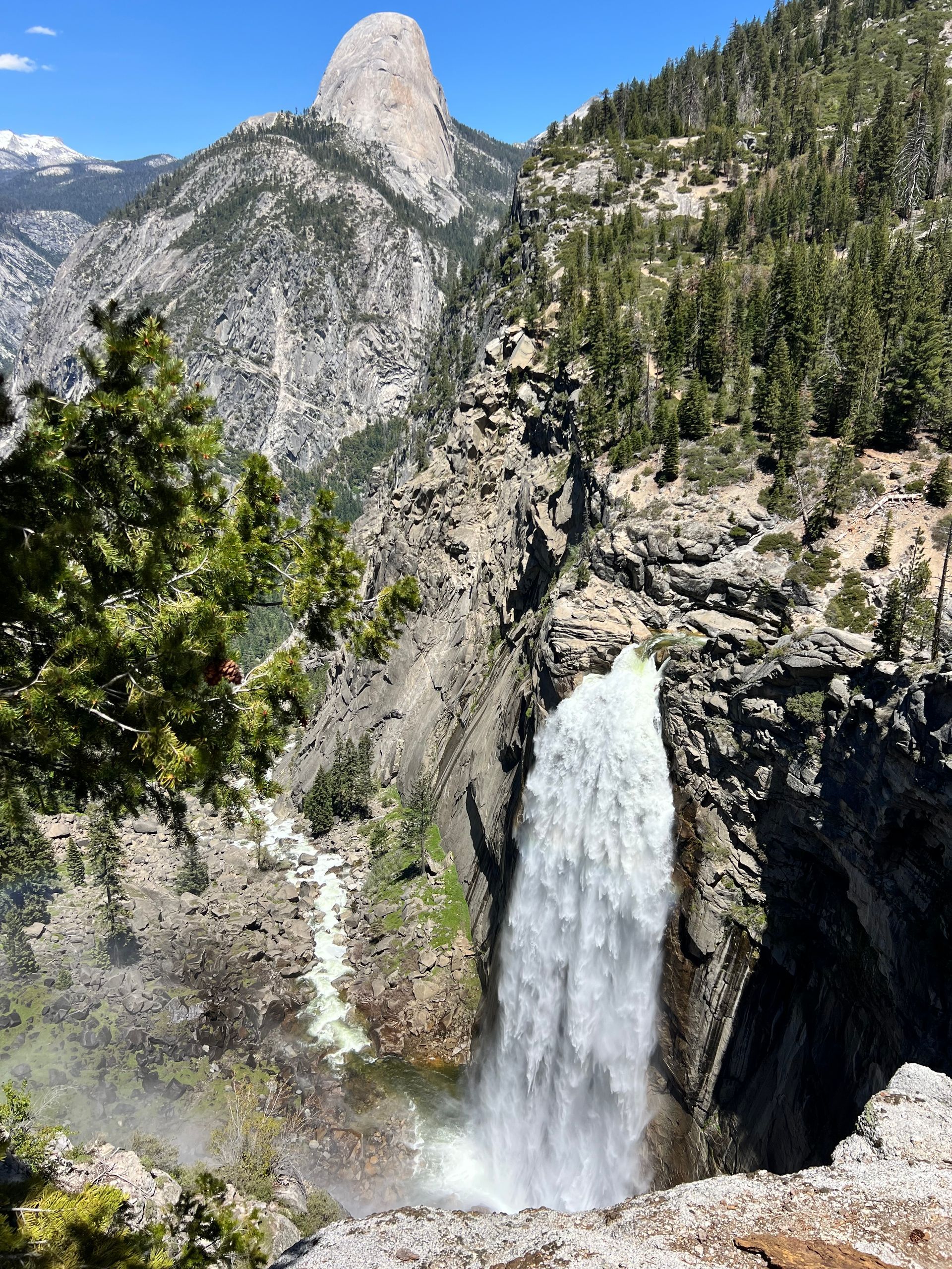 A waterfall in the mountains with a mountain in the background