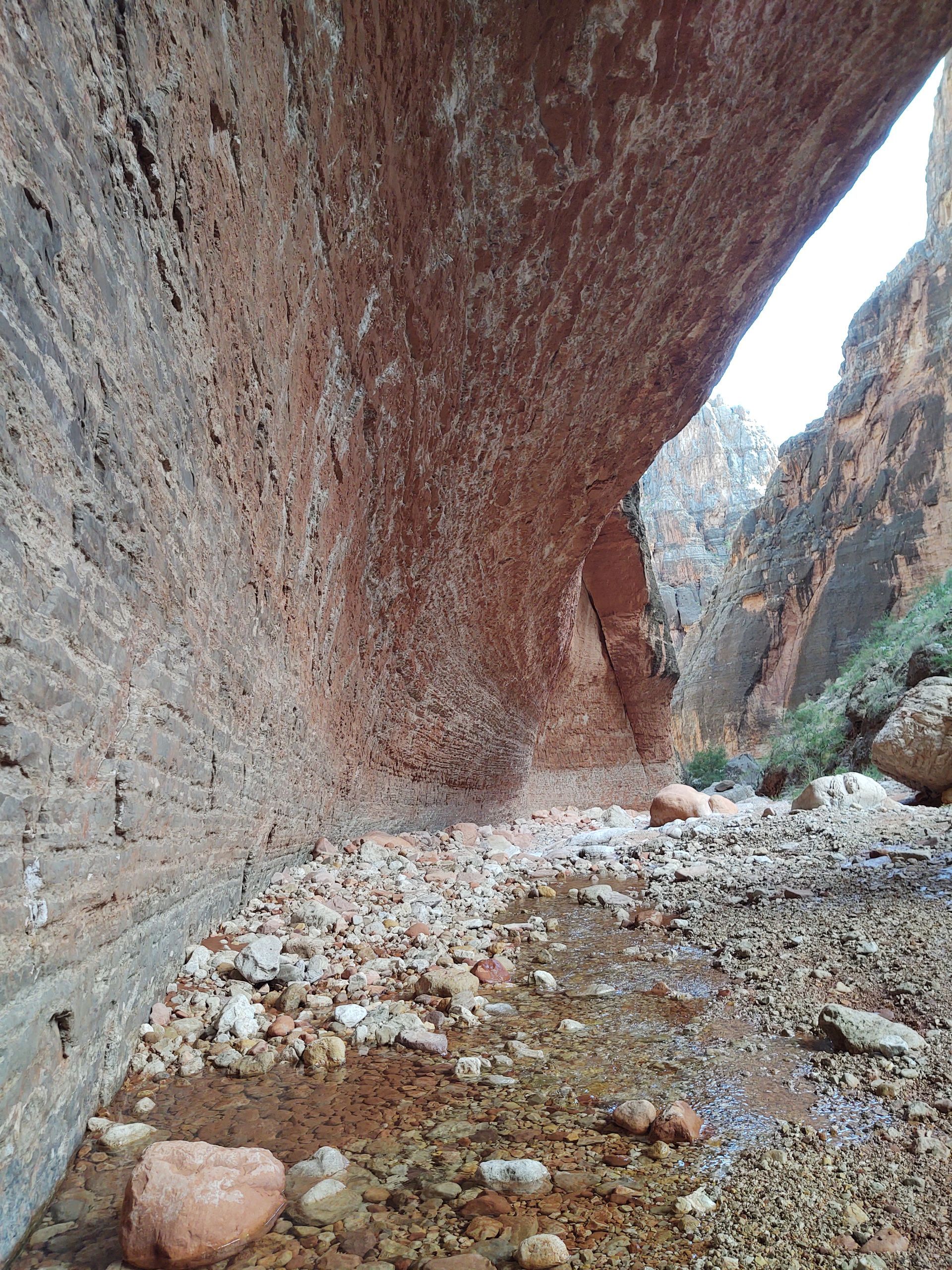 A narrow canyon filled with rocks and water.