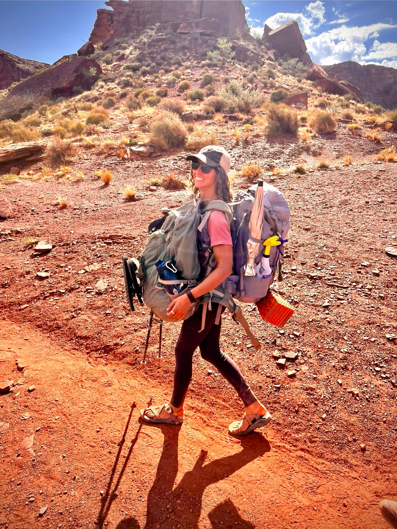 a woman hiking with multiple bags on them
