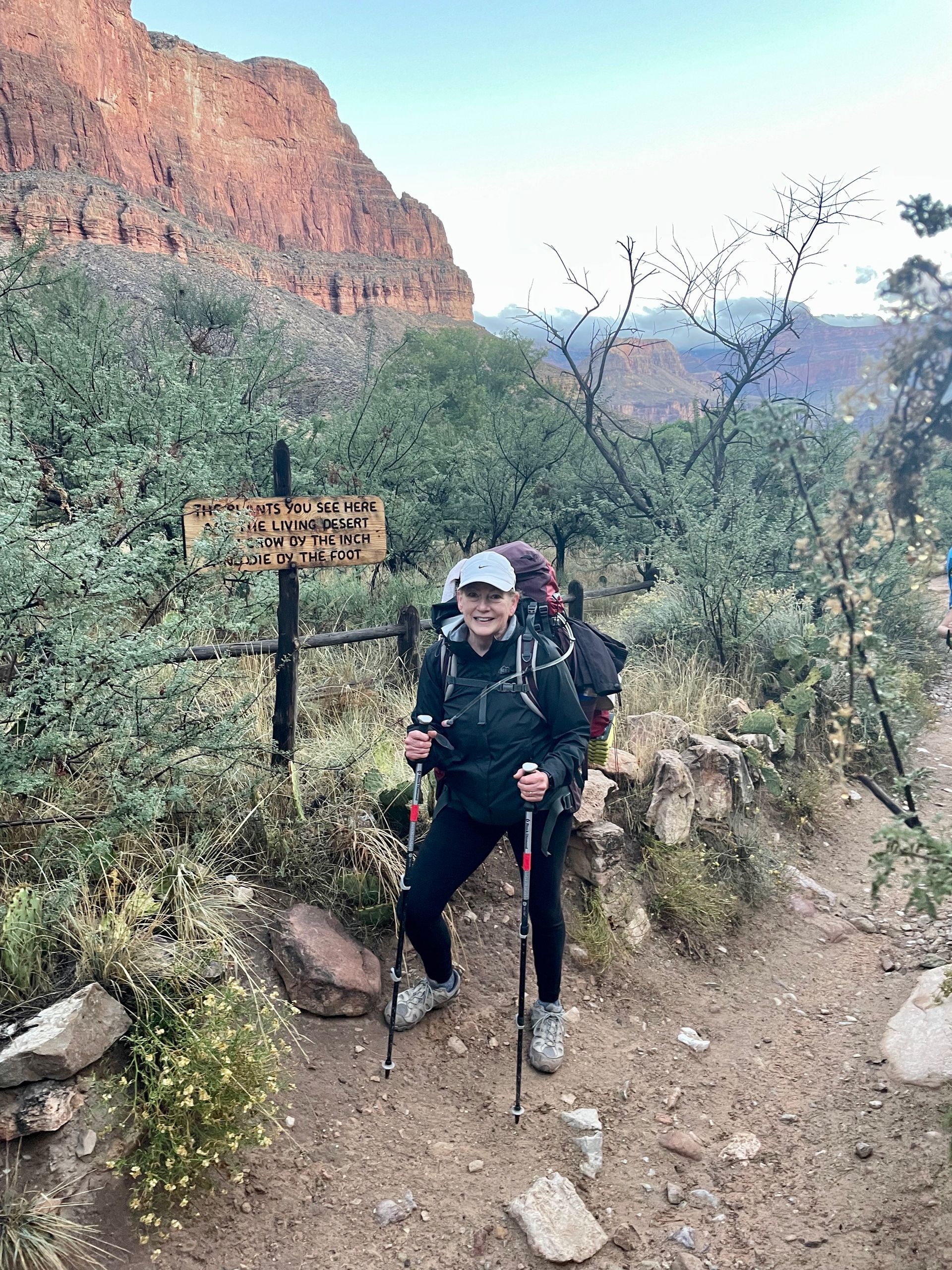 A woman is hiking on a trail in the mountains.