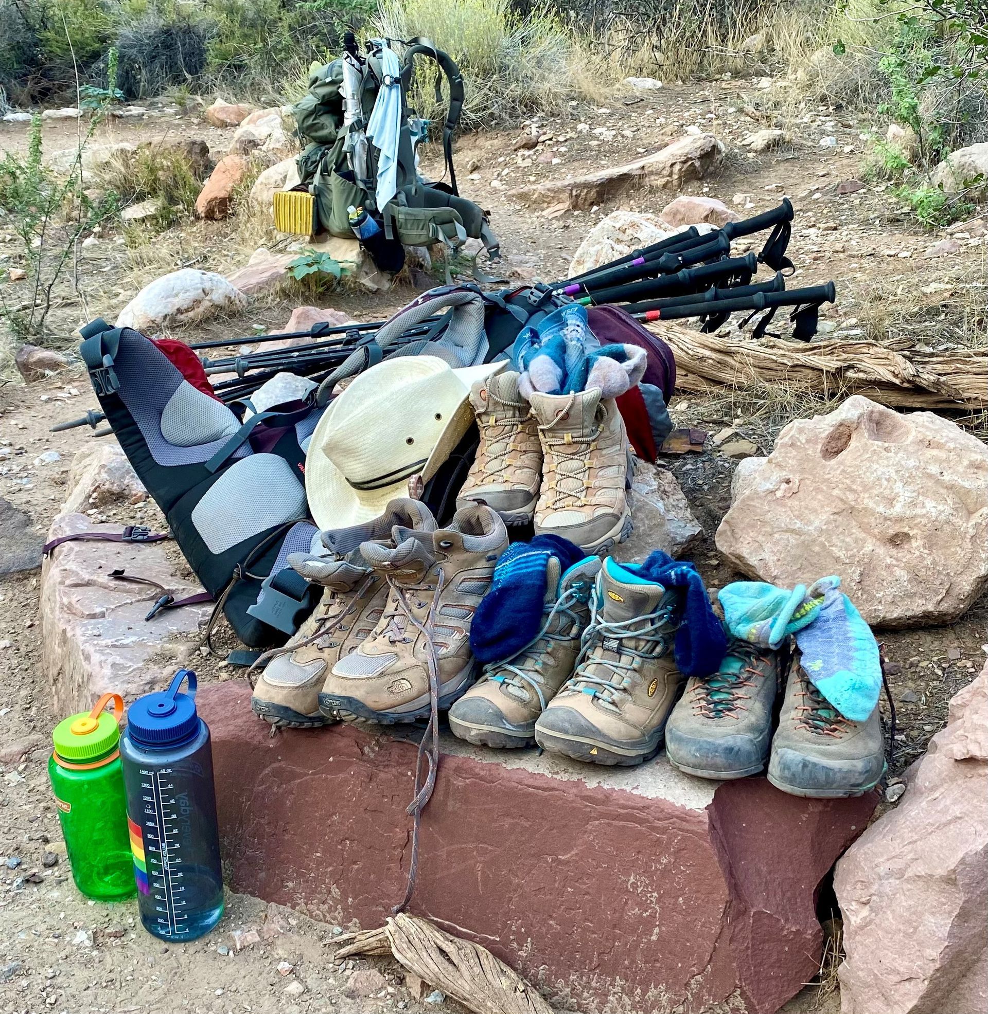 A pile of hiking gear is sitting on top of a rock.