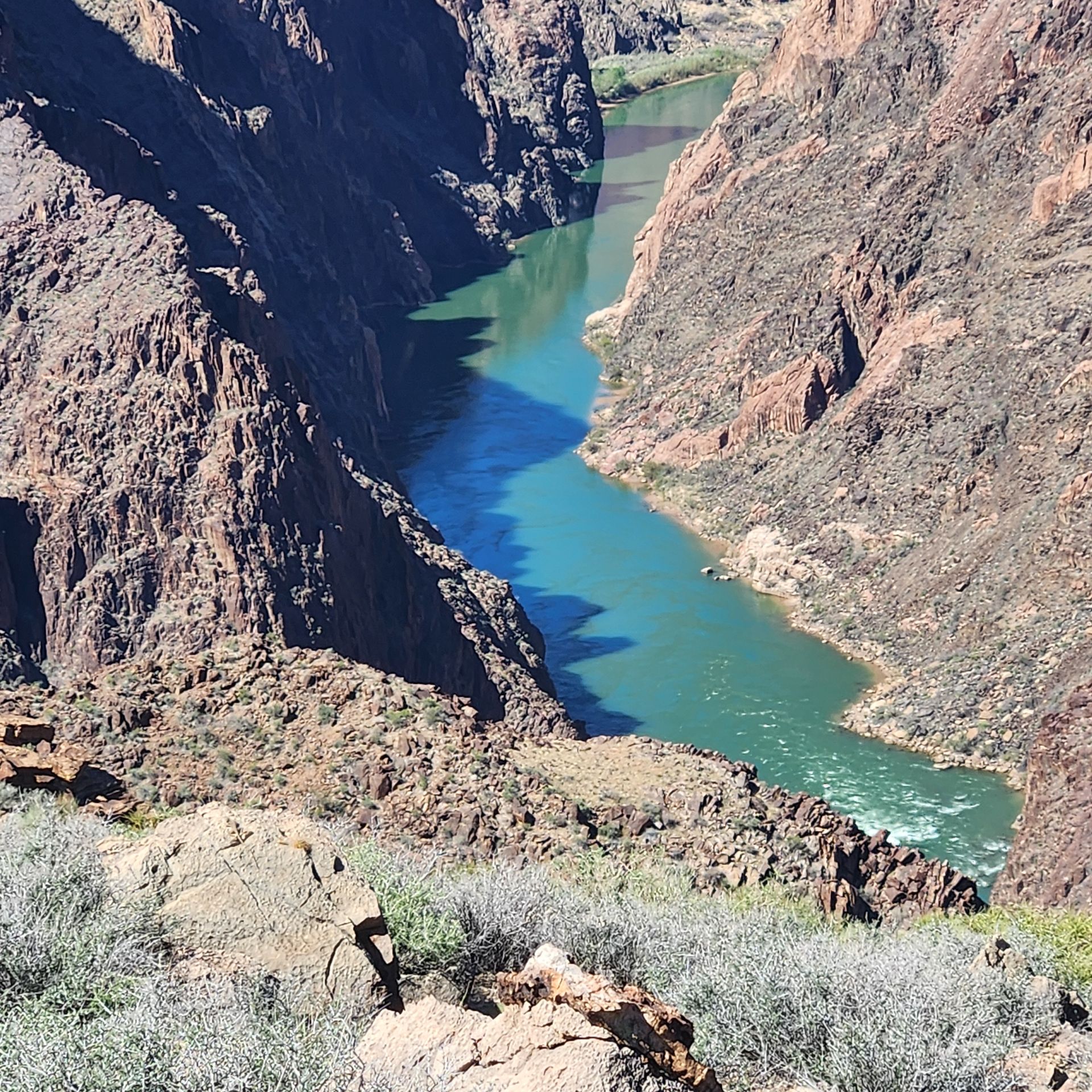 River winding through a deep canyon with reddish-brown rock walls.