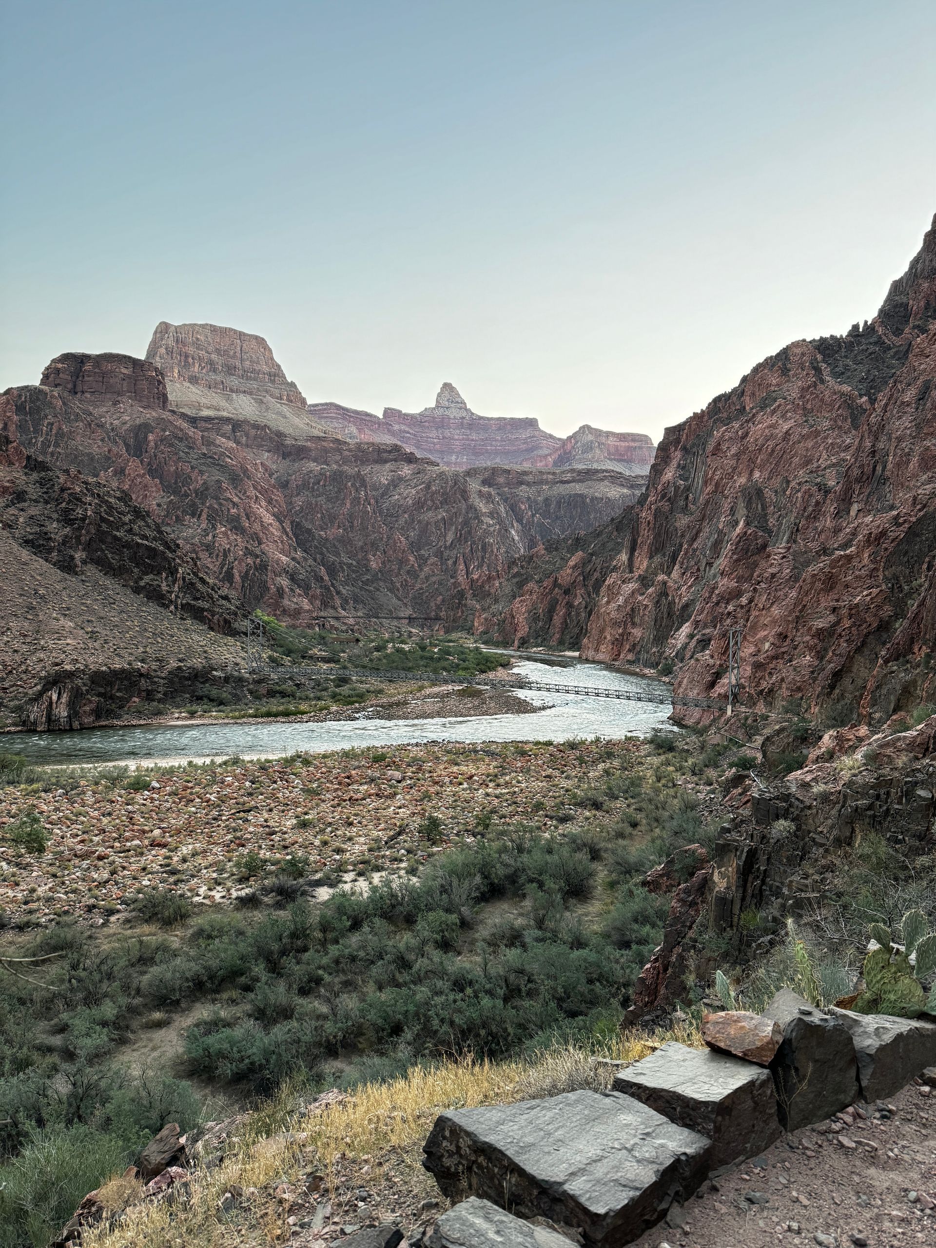 A river running through a canyon with mountains in the background.