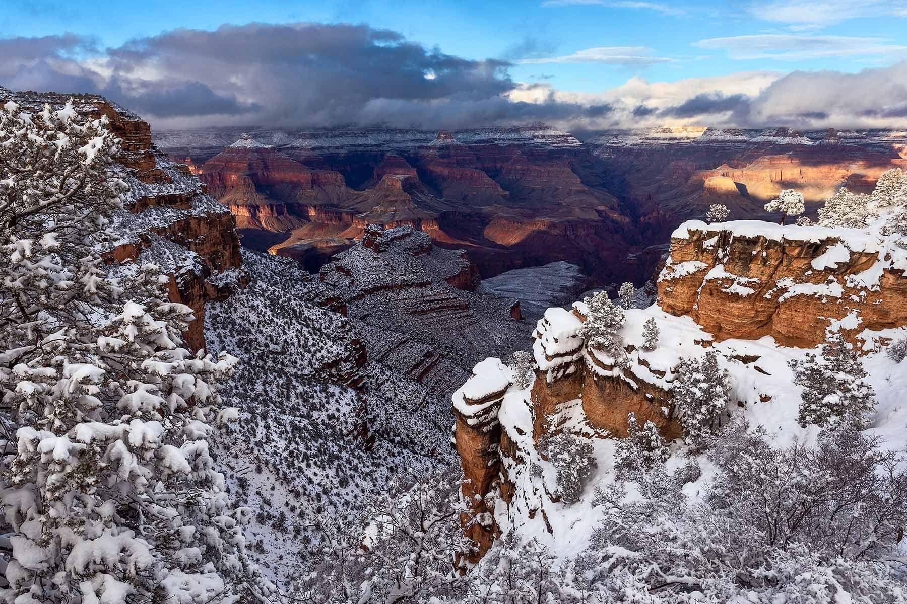 Snow-covered canyon cliffs under a blue sky at sunset