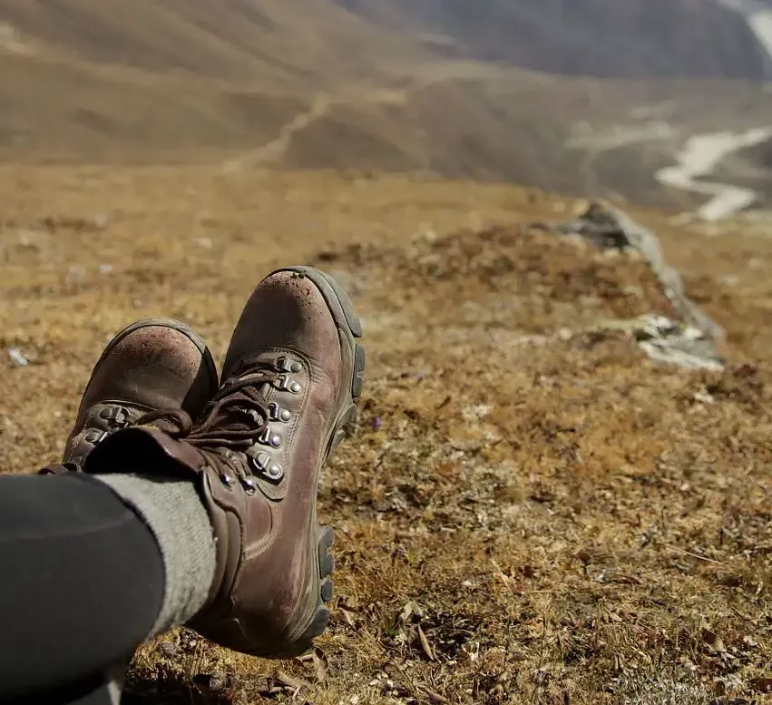 A person is laying on a hill with their feet up.