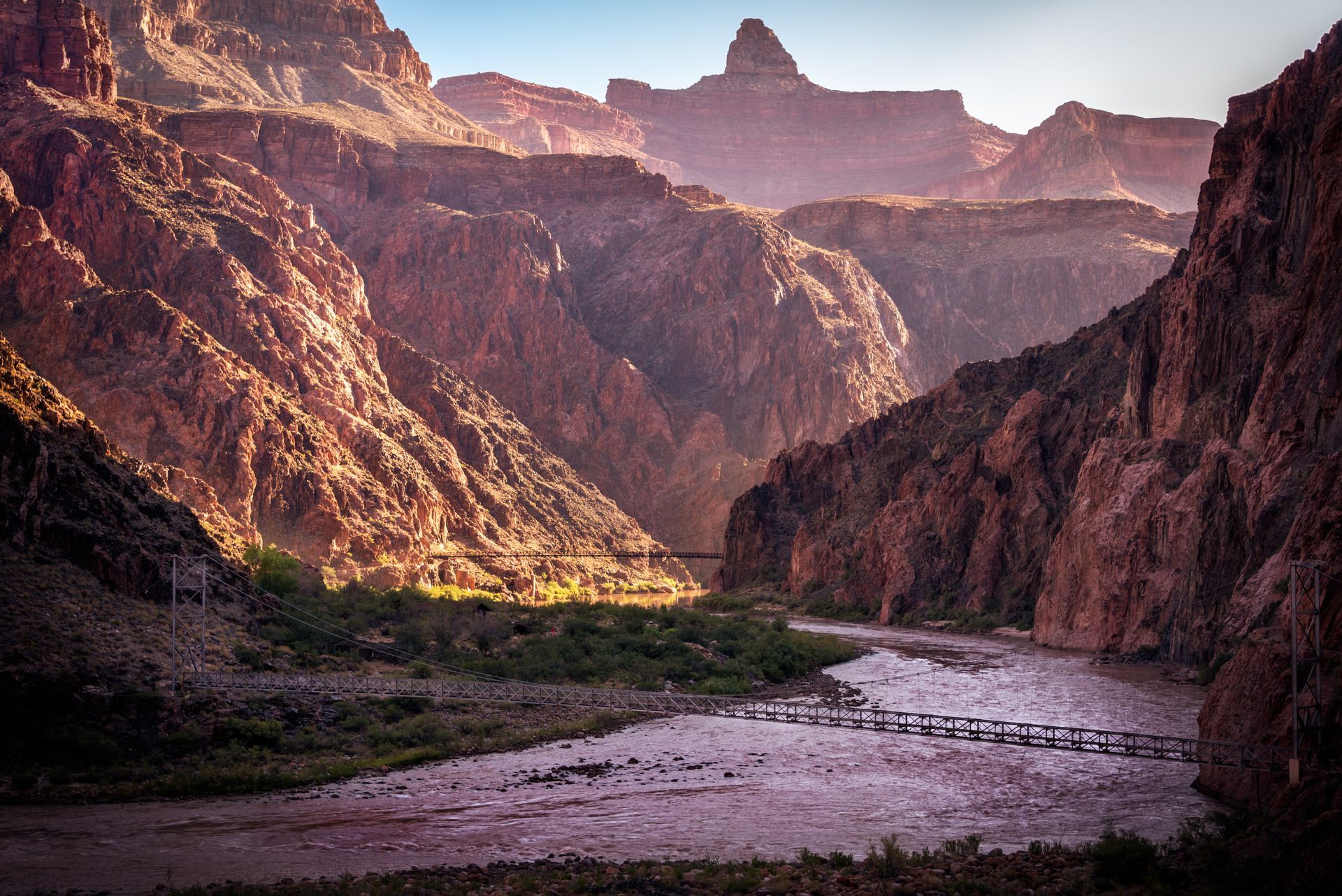 An aerial view of the grand canyon at sunset with trees in the foreground.