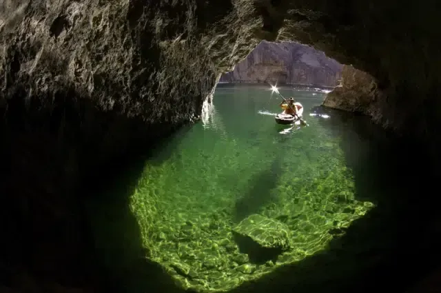 Two people are rowing kayaks on a lake