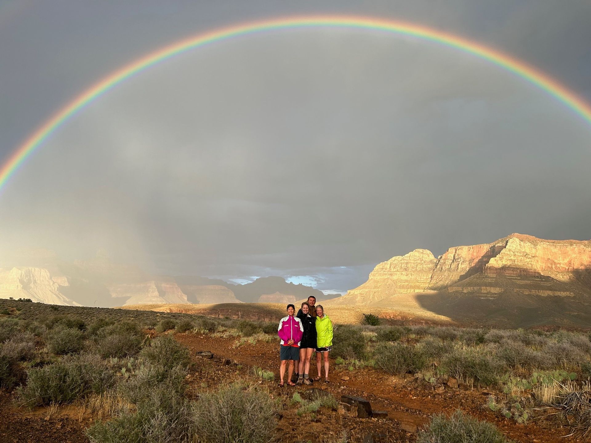 People standing under a giant rainbow in the southwest