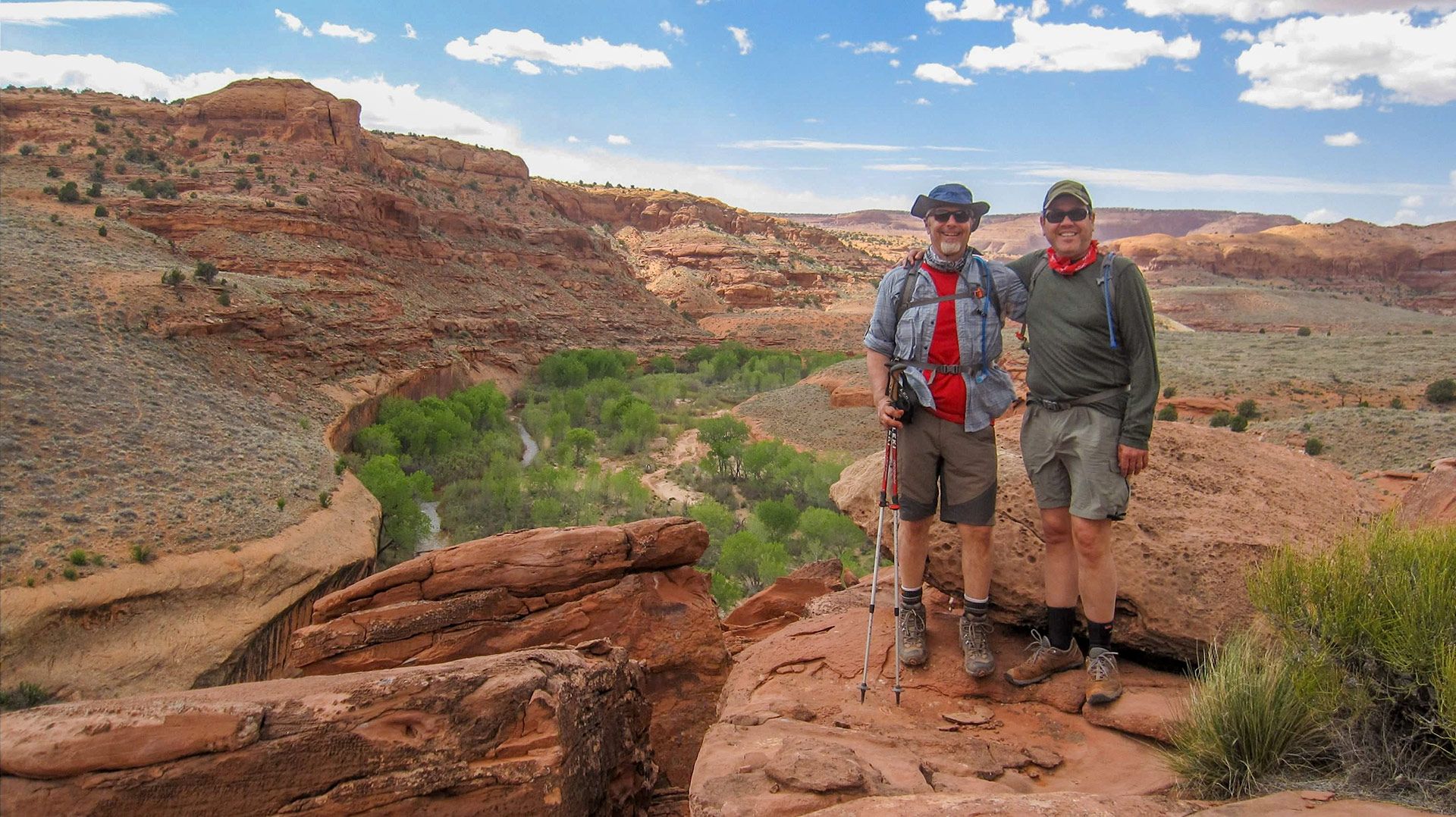 People stand along the edge of a cliff in the southwest