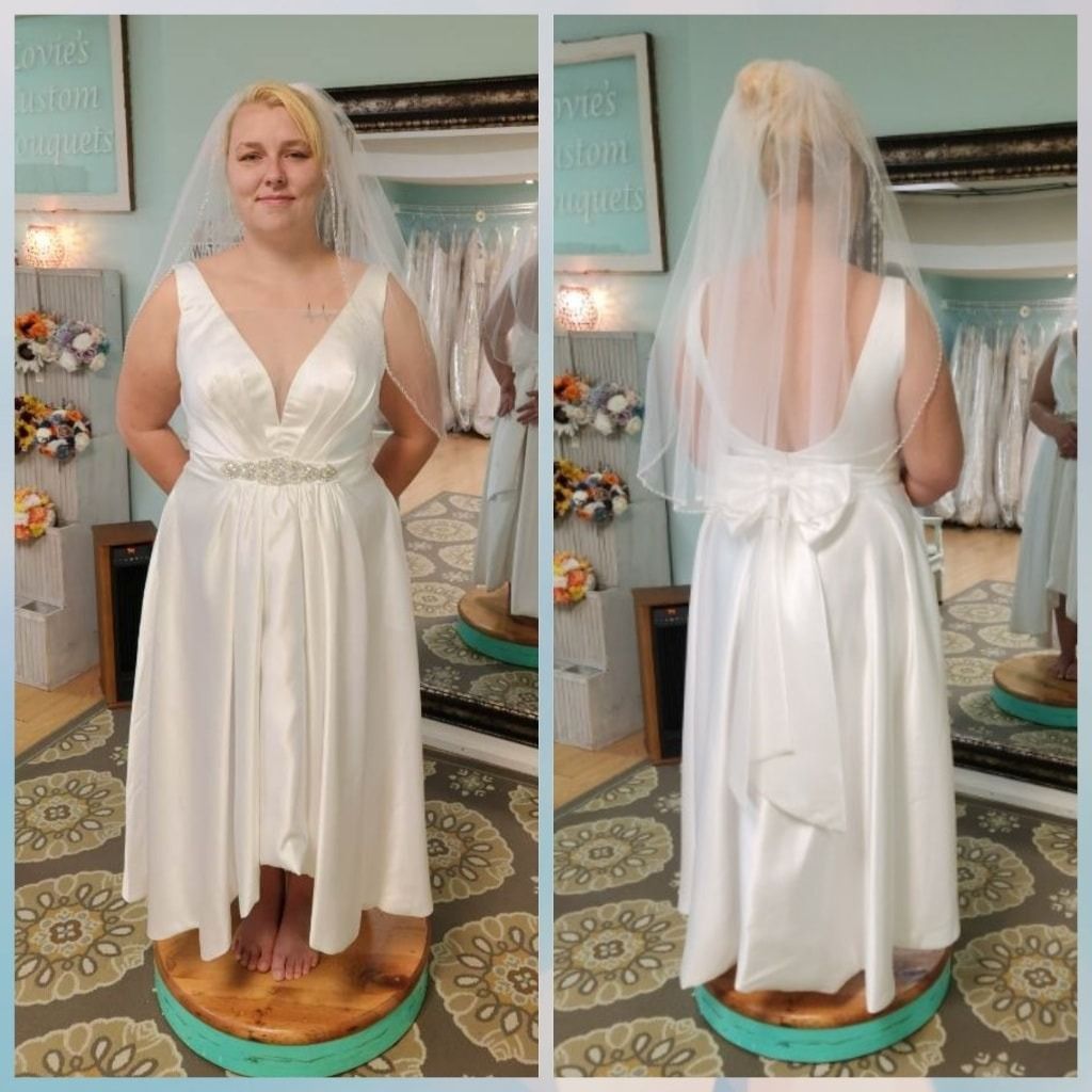 White wedding dress shown front and back on a mannequin in a bridal shop