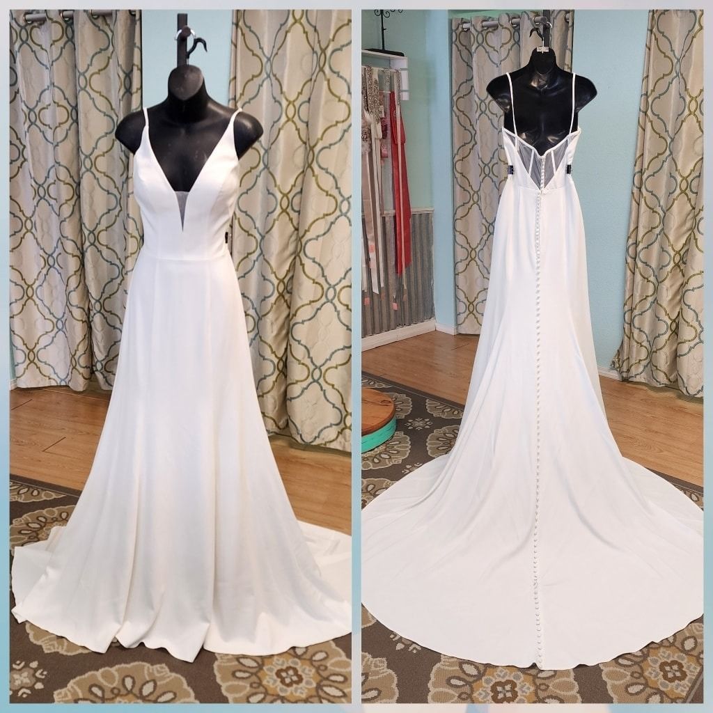White wedding gown with black bodice displayed front and back on mannequins in a room
