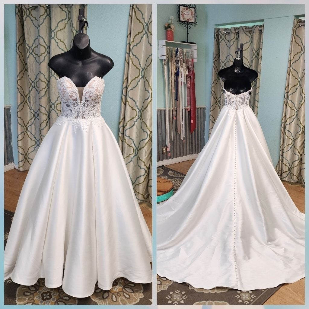 White strapless wedding gown with lace bodice, shown front and back on a mannequin in a shop