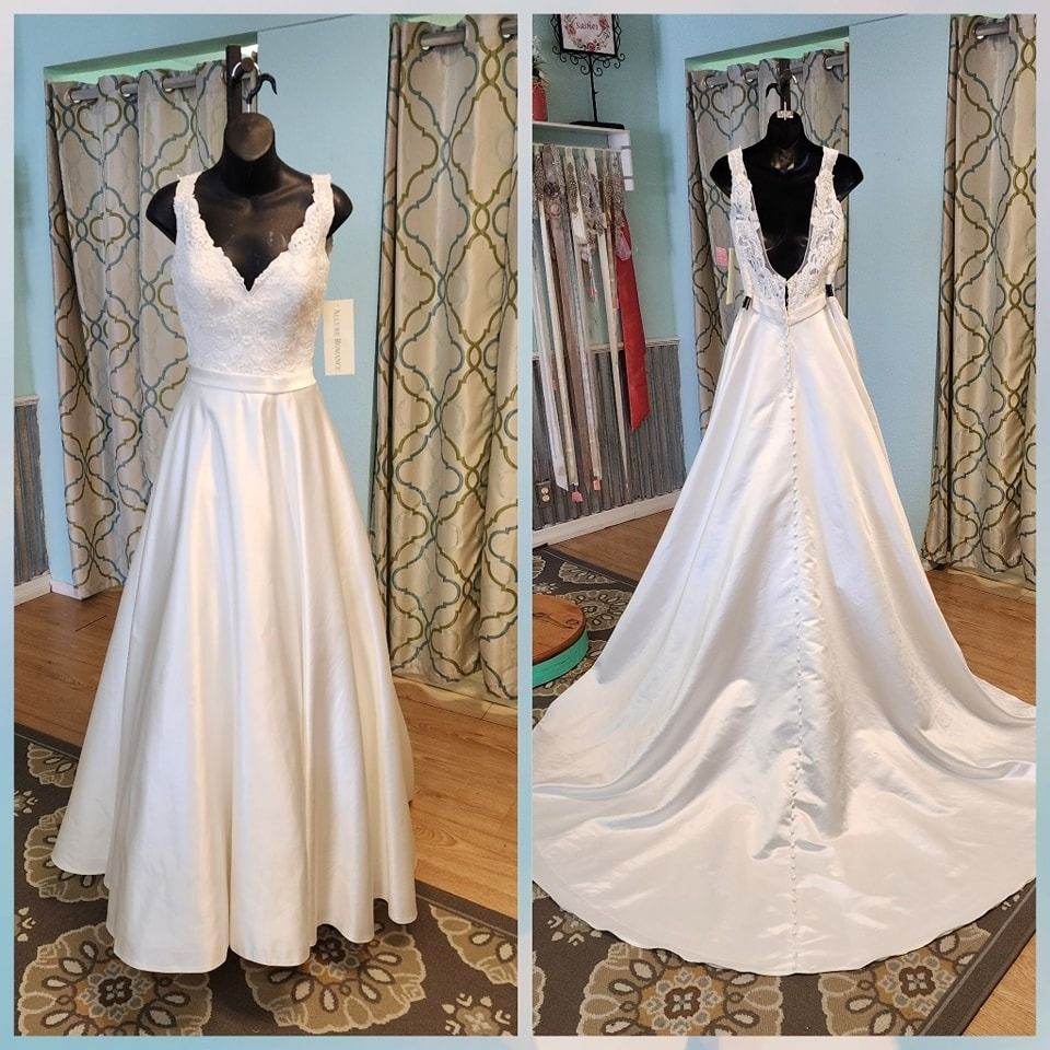White sleeveless lace wedding dress on a mannequin, shown front and back in a boutique.