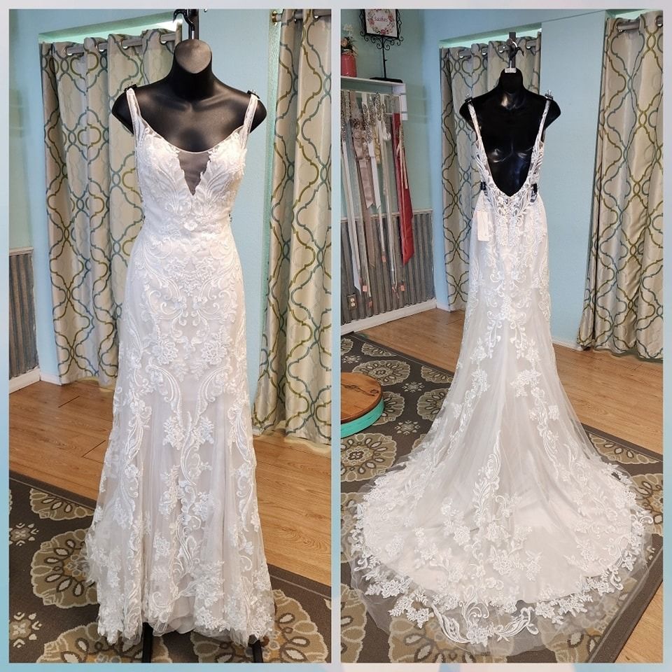 White lace wedding gown displayed on a black mannequin, shown front and back in a boutique