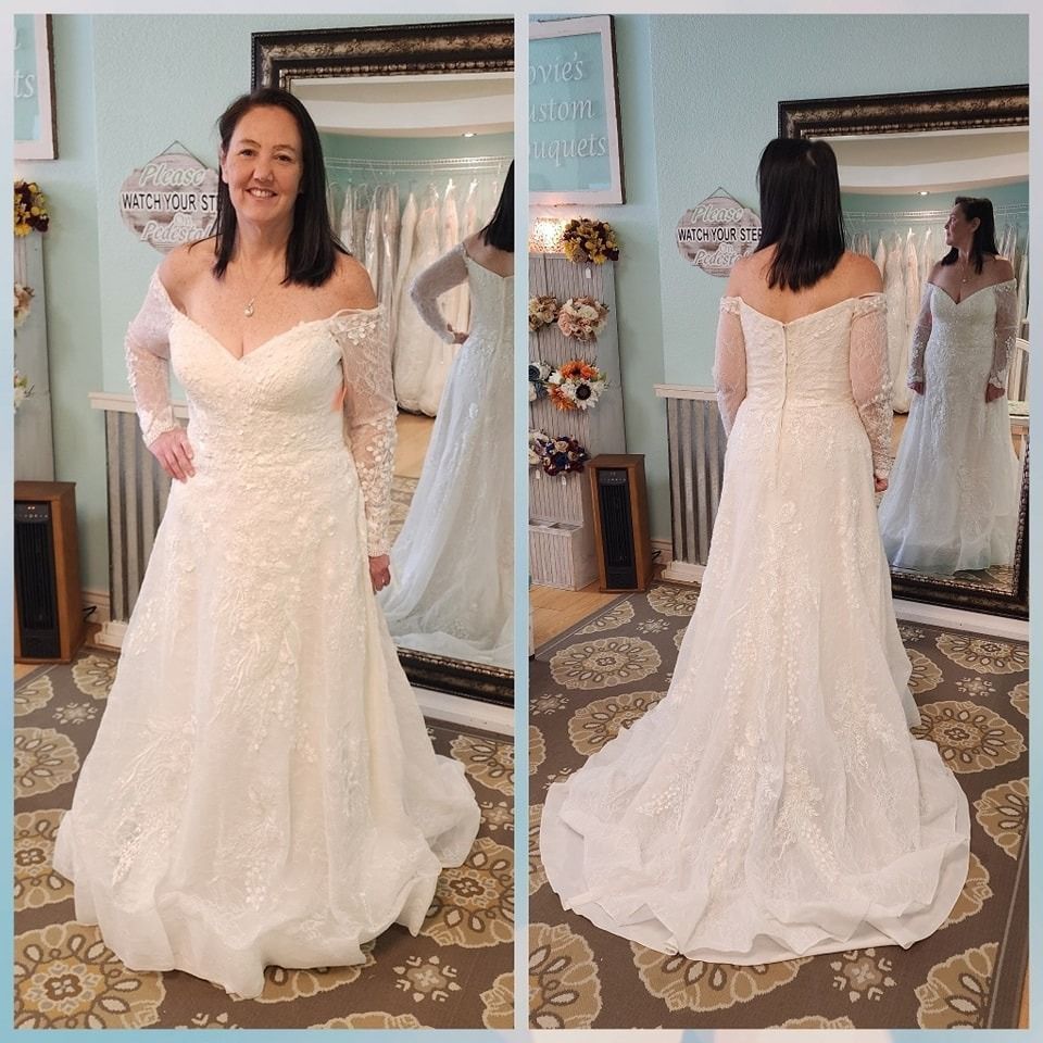 Woman modeling a white lace wedding dress, front and back view in a bridal shop.