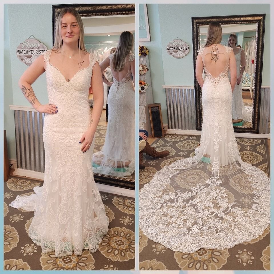 Woman in a white lace wedding dress shown front and back in a mirrored room