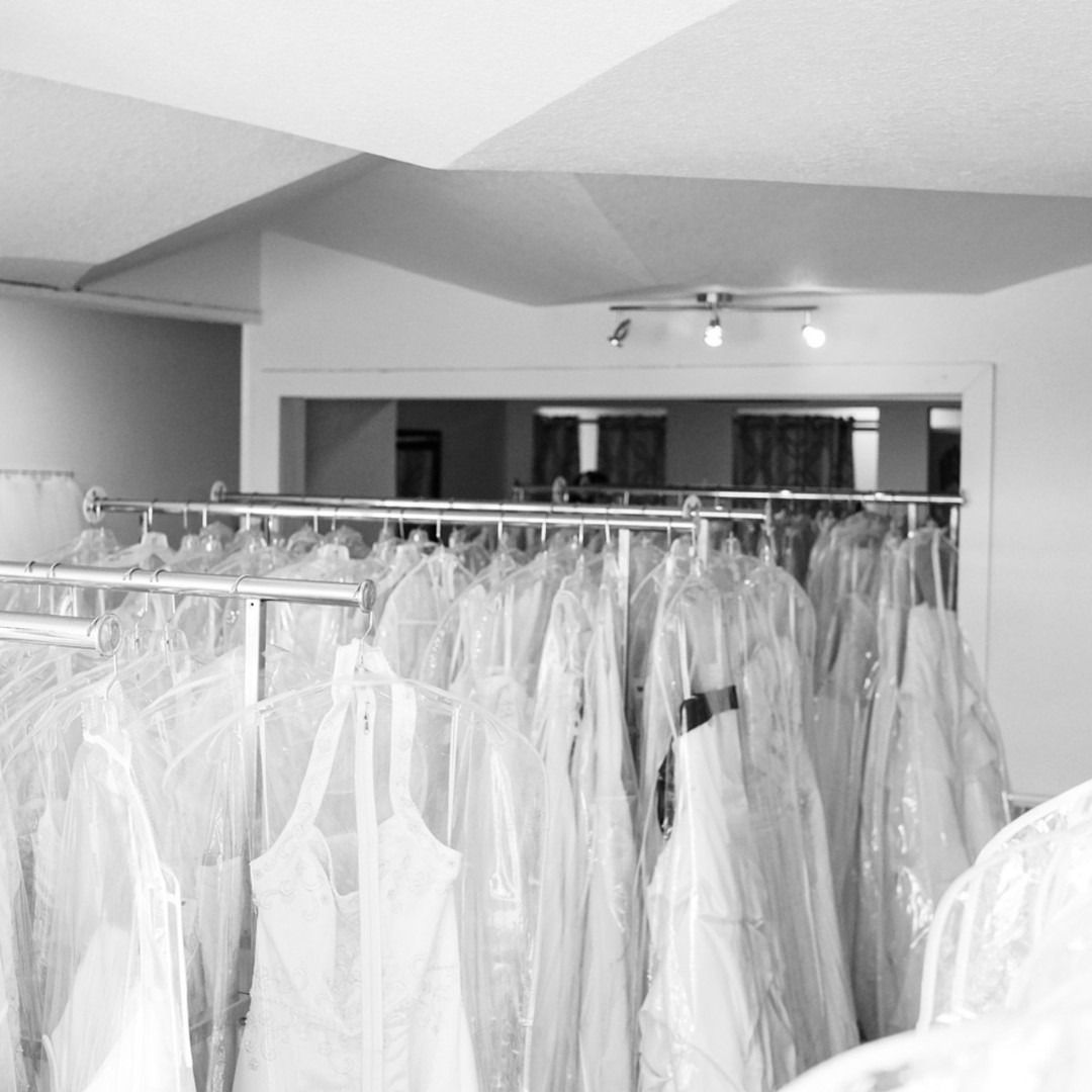 Clothing racks filled with white garments in a bright boutique dressing room