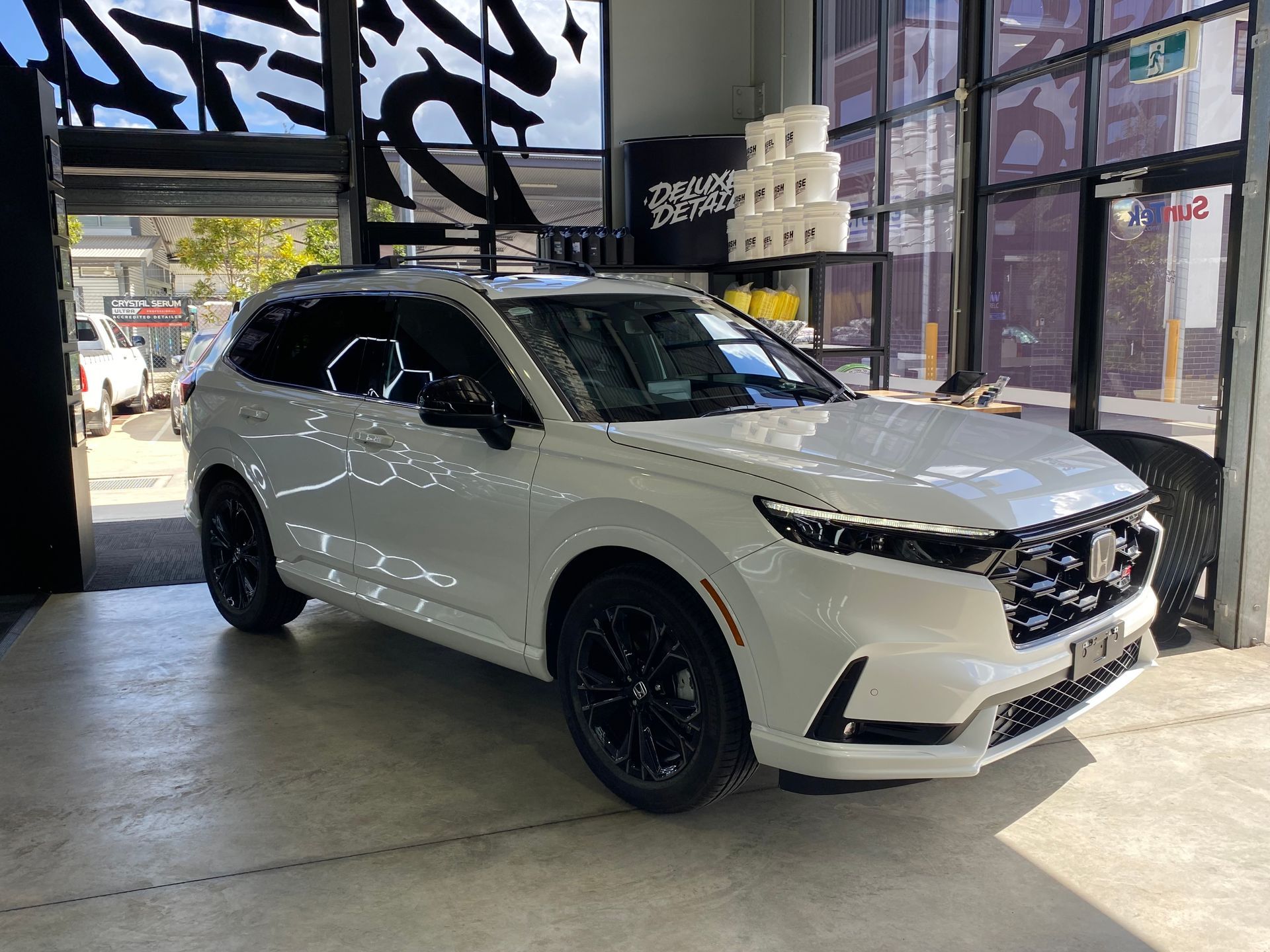 A white suv is parked in a showroom.