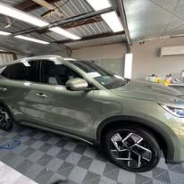 A green car is parked in a garage.
