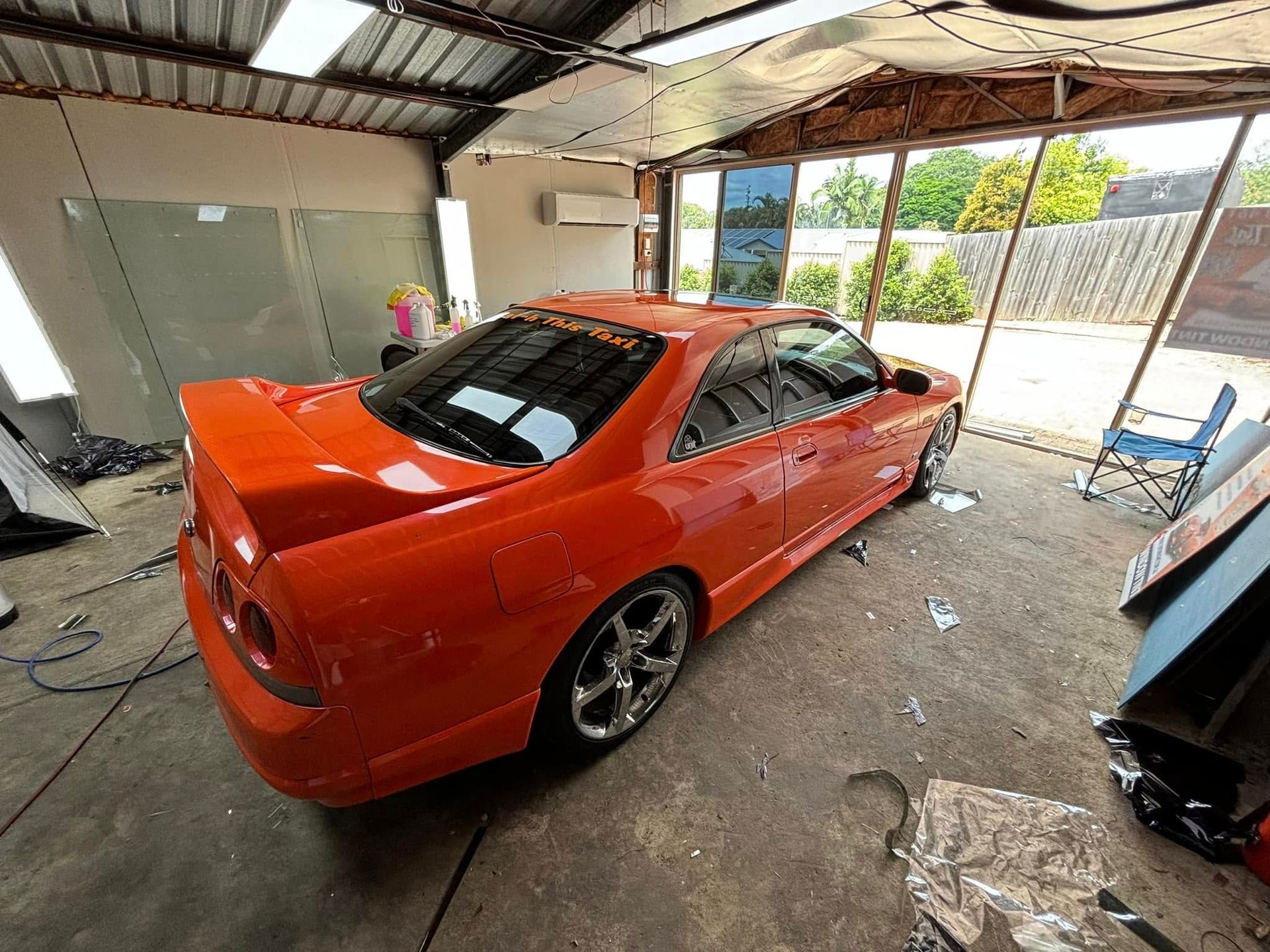 An orange car is parked in a garage.