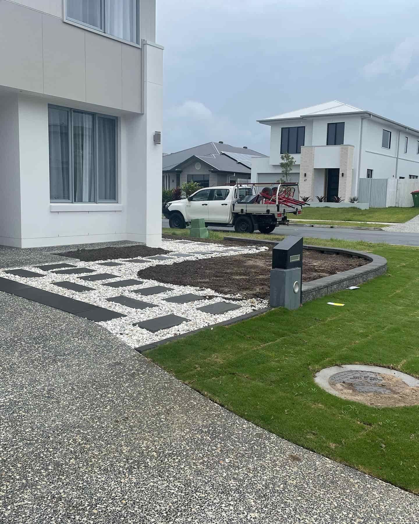 A white truck is parked in front of a white house. — Turnscape Landscaping In Broadbeach, QLD