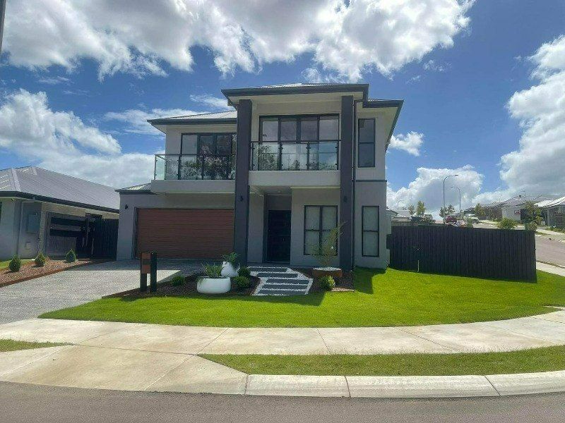 A Large House With a Lot of Windows is Sitting on Top of a Lush Green Lawn — Turnscape Landscaping In Broadbeach, QLD