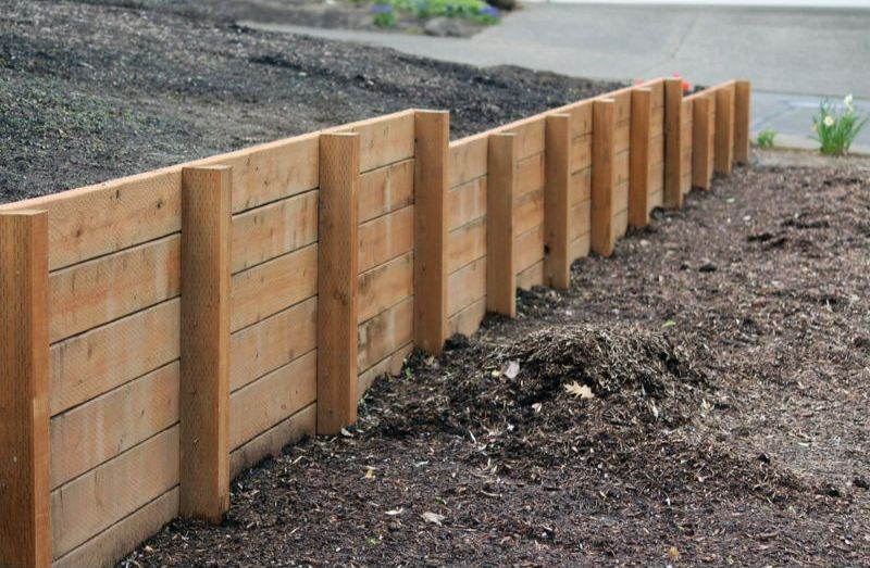 A Wooden Fence is Sitting on Top of a Pile of Dirt  — Turnscape Landscaping in Hope Island, QLD