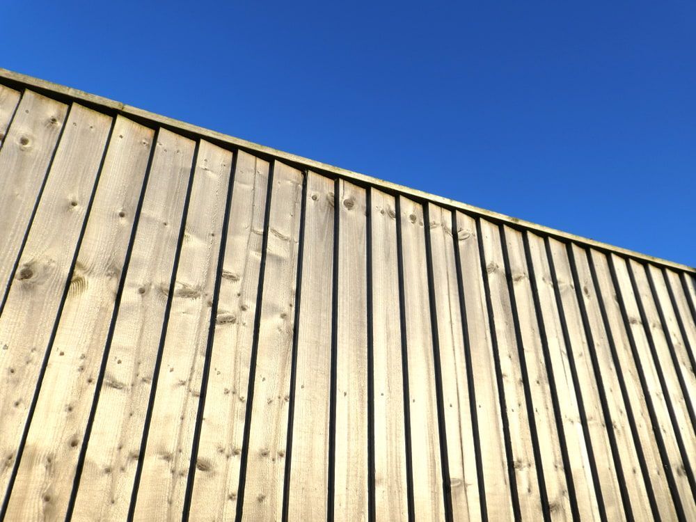 A wooden fence with a blue sky in the background — Turnscape Landscaping In Broadbeach, QLD