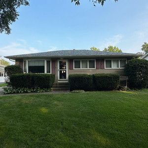 A house with a lush green lawn in front of it.