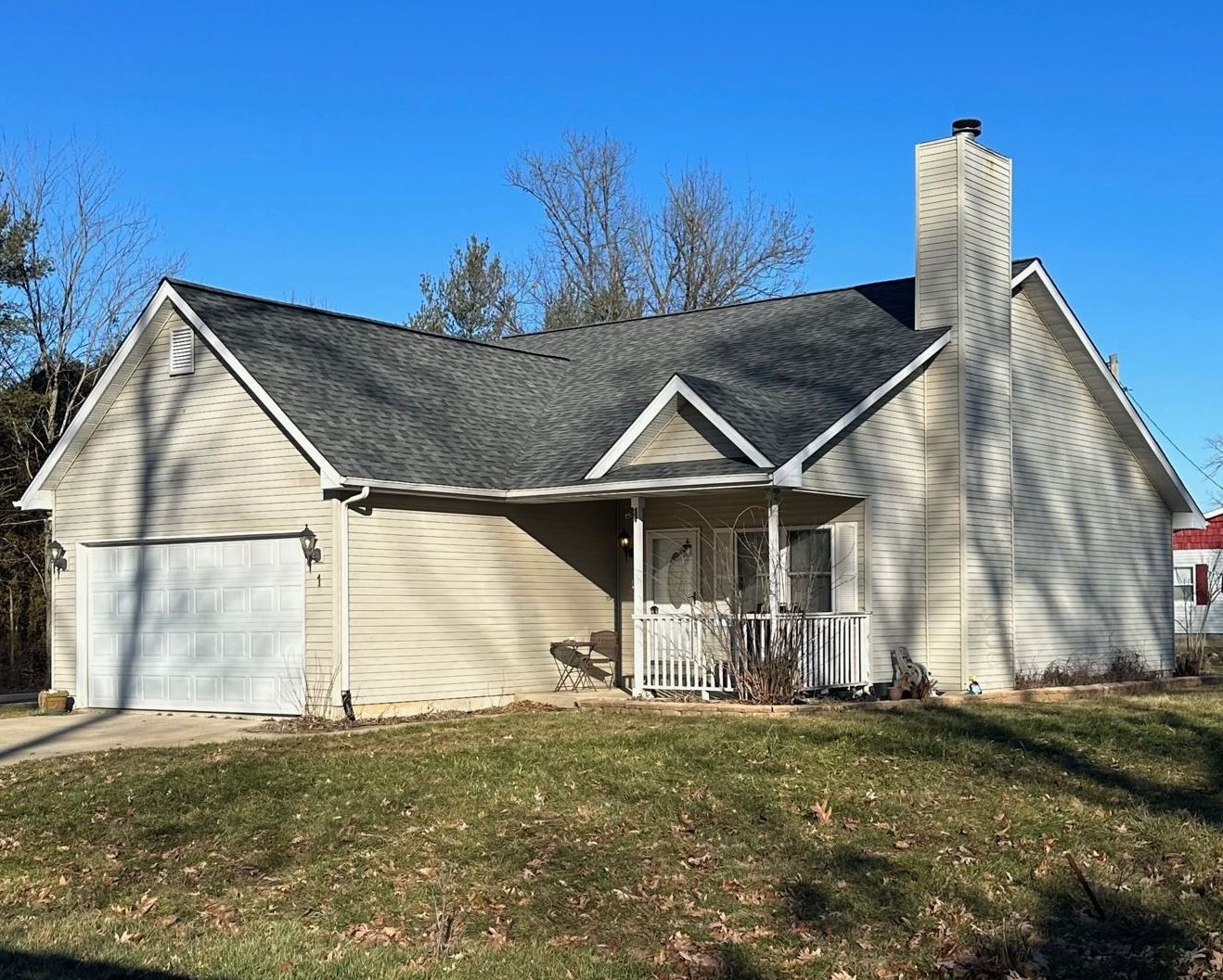 A house with a gray roof and a white garage door