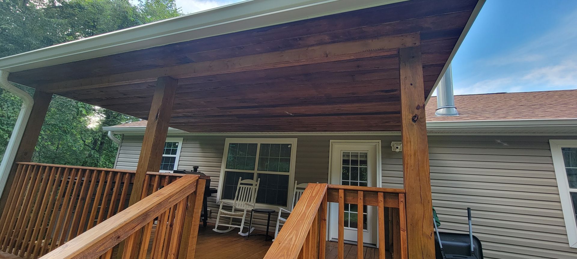 A house with a wooden deck and a covered porch.