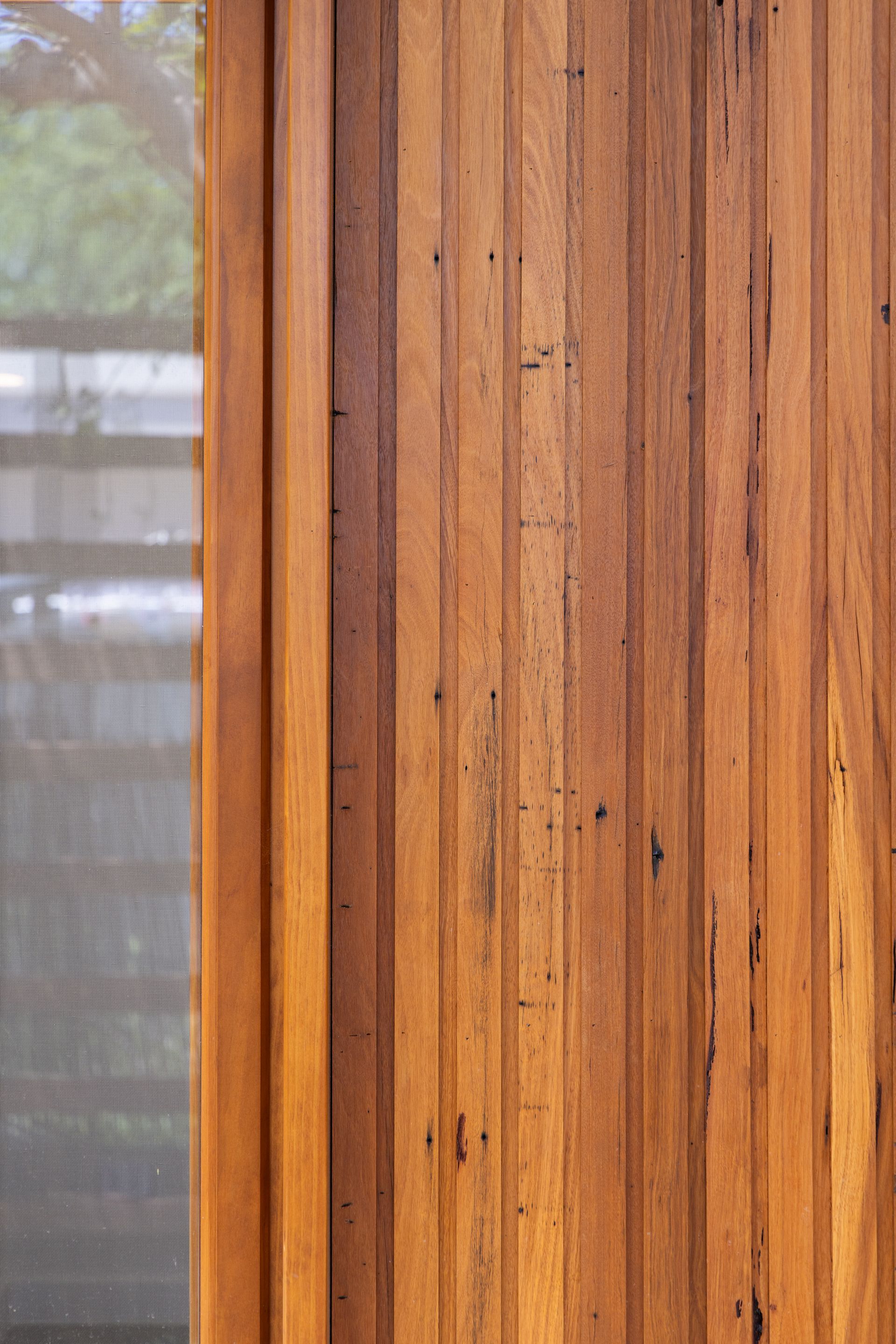 Wooden wall paneling beside a frosted glass window.