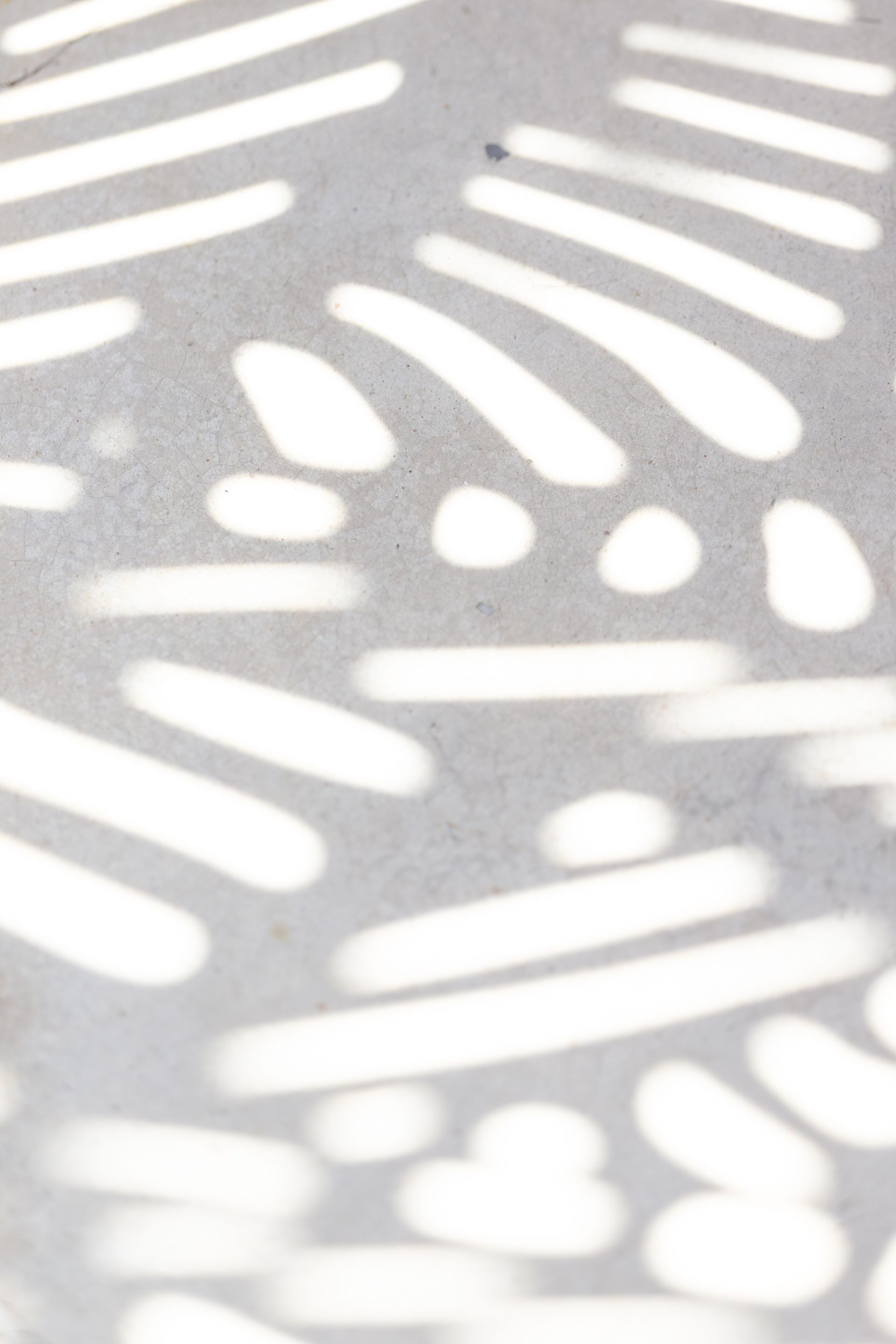 Abstract white light patterns cast on a gray surface.