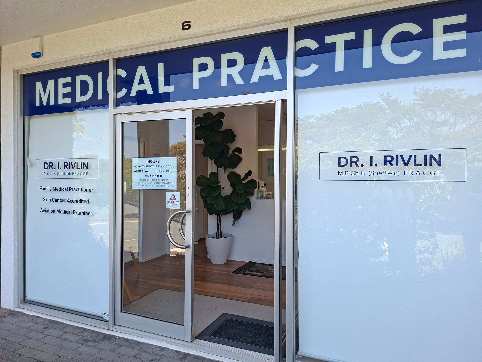 Medical practice entrance with glass doors and blue sign, Dr. Irvlin name on windows