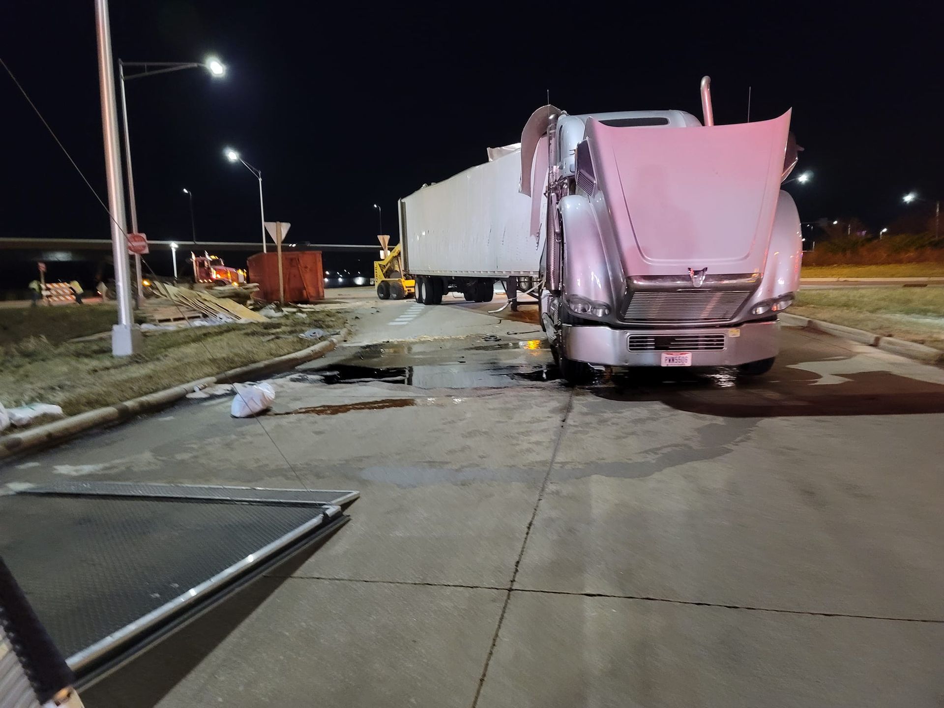 A truck with its hood up is parked on the side of the road.