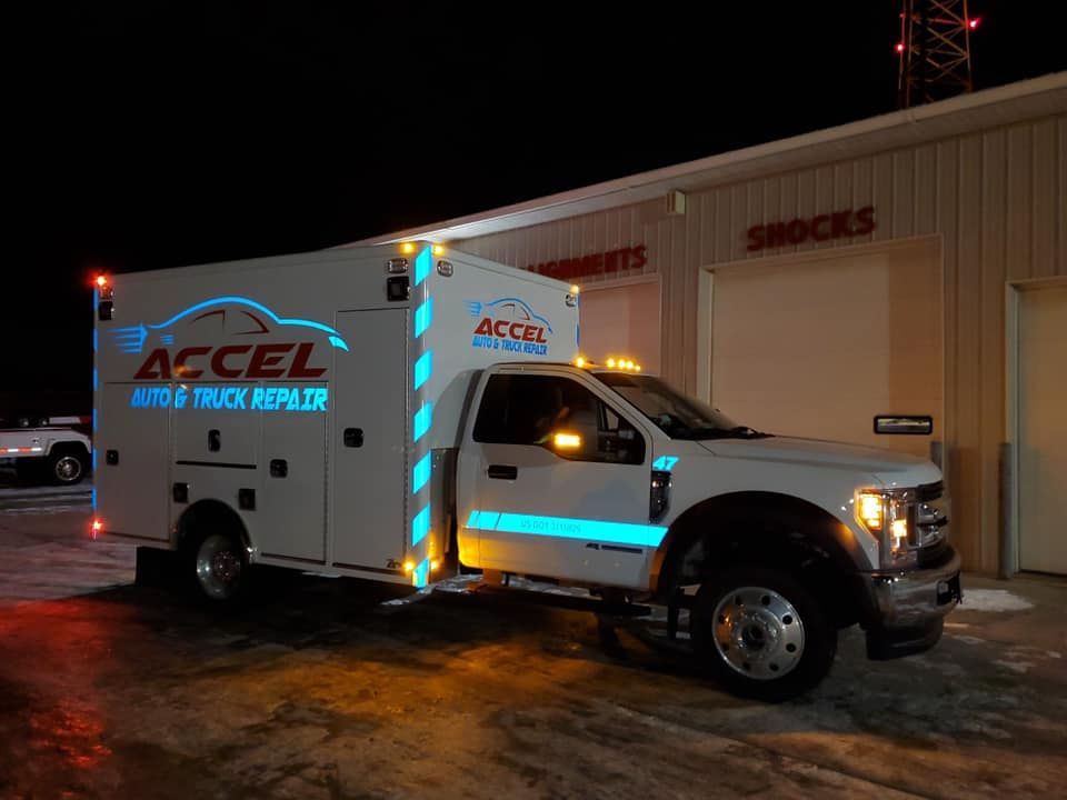 An ambulance is parked in front of a building at night.