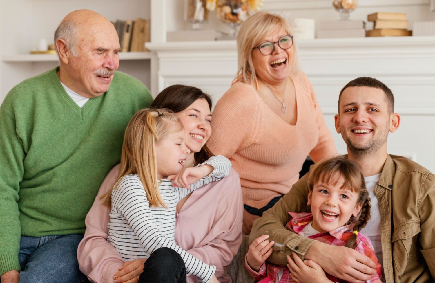 Multi-generational family smiling on a couch in a bright living room