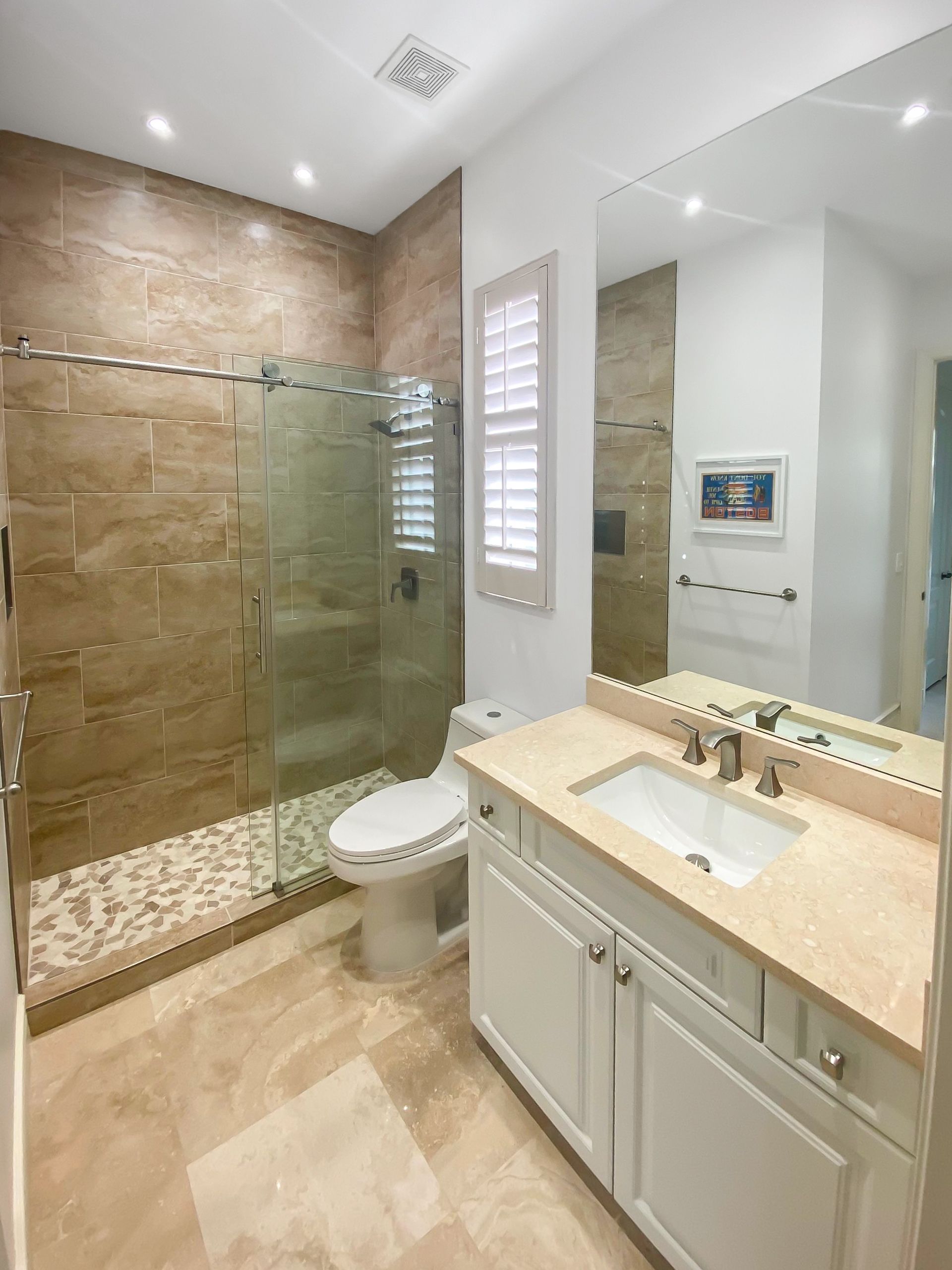 A bathroom with a toilet a sink and a walk in shower