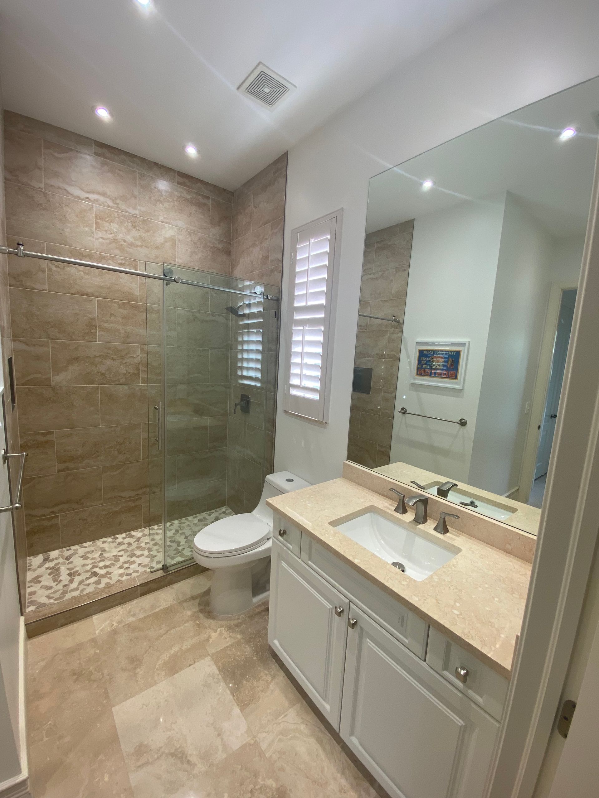 A bathroom with a toilet , sink , and walk in shower.