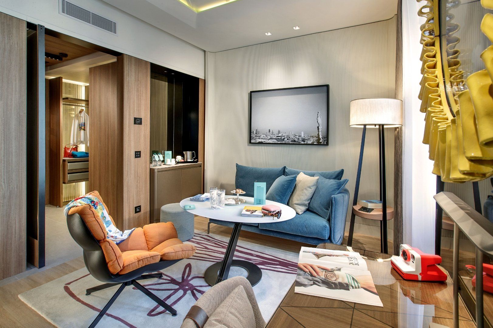 L'accogliente lounge di un hotel è arredata con un divano blu, una poltrona arancione, un tavolino da caffè.