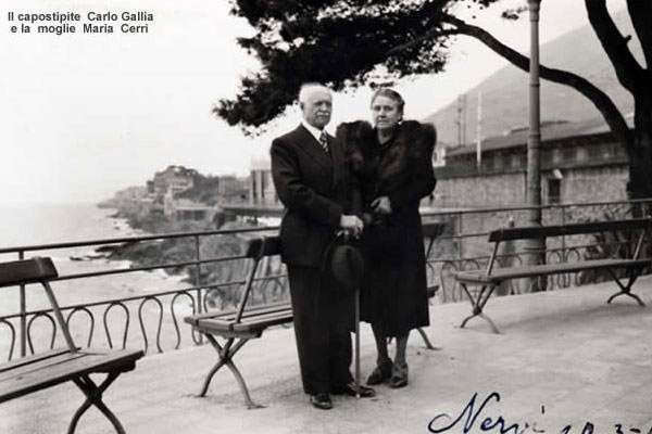 卡洛·加利亚和玛丽亚·切里站在内尔维的海滨长廊上，背景是大海和石墙。