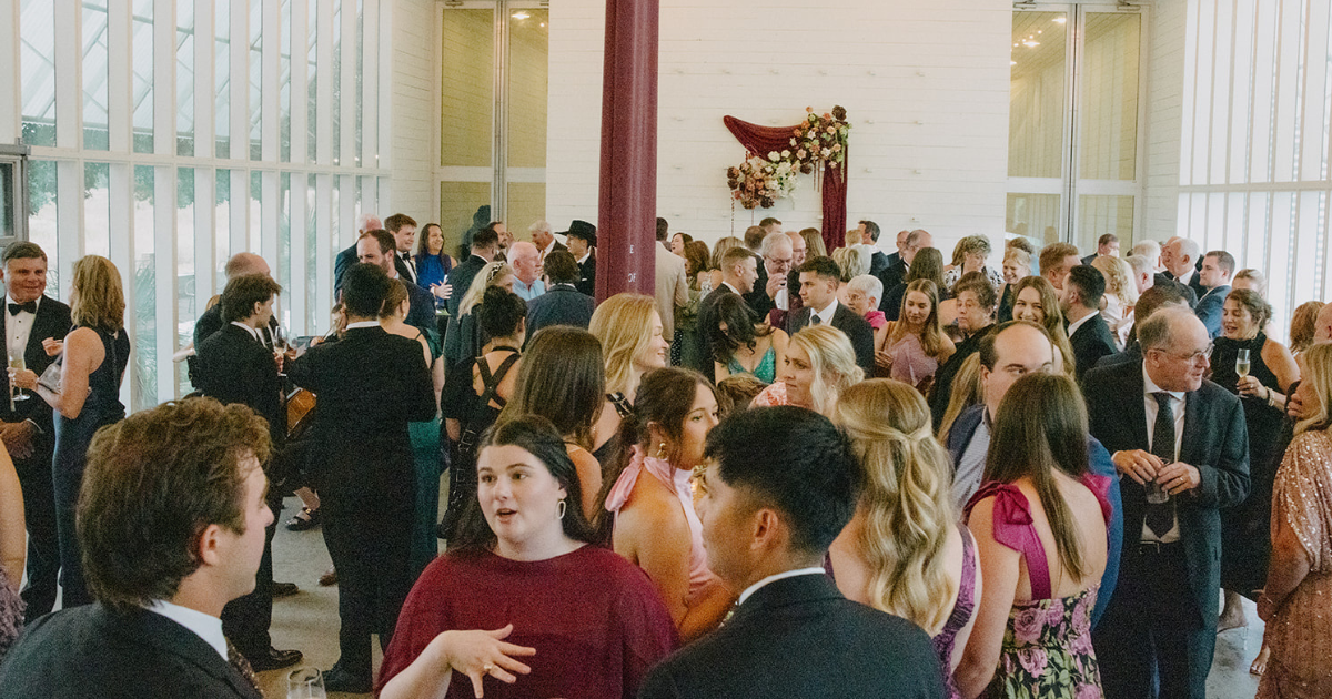 Crowded indoor social event with guests mingling in a bright room
