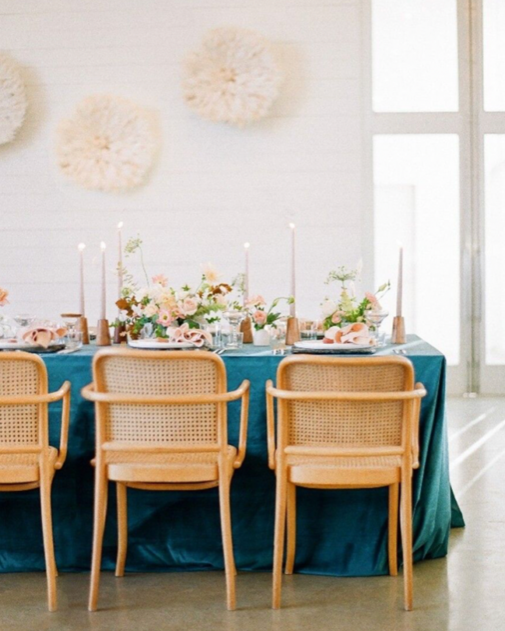 A dining room table with a blue table cloth and chairs